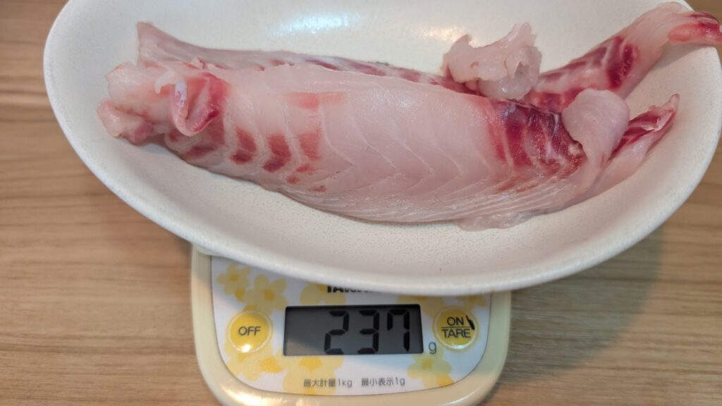 クロダイの切り身をキッチンスケールで量り、237グラムと表示されている様子